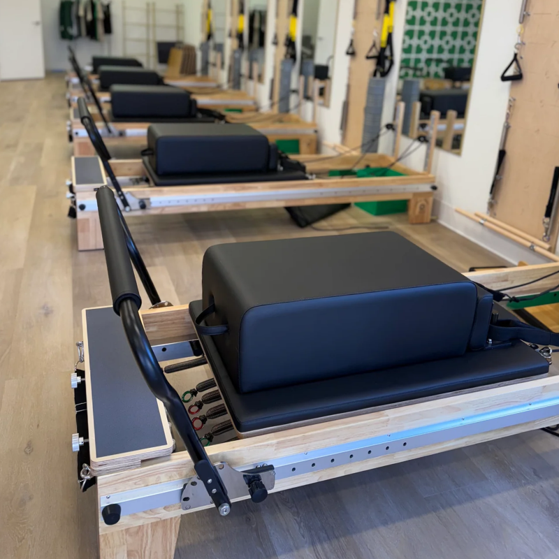 Five of the Core Collab Full Track Eco Studio Reformer Pilates Machine inside a Pilates studio