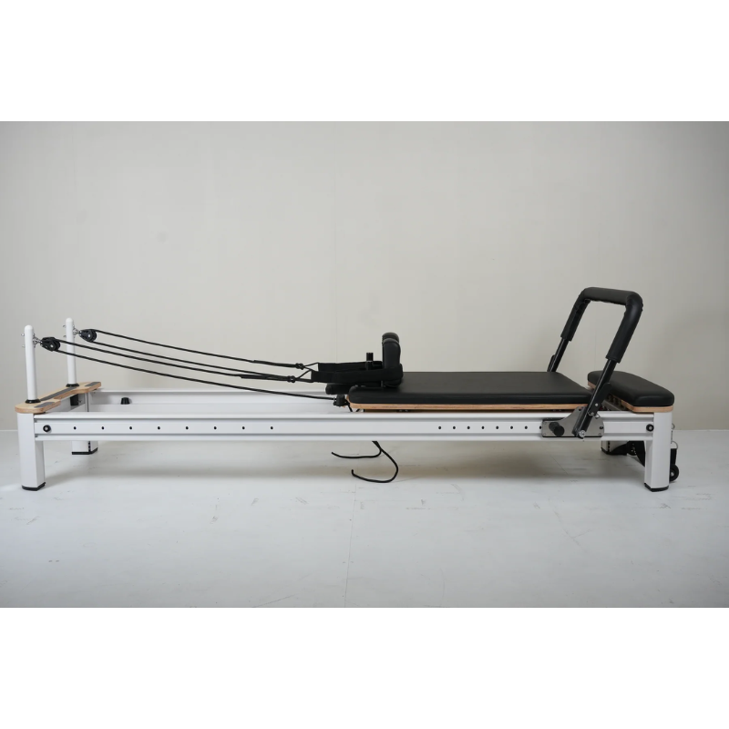 Side view of Core Collab Full Track Queen Studio Pilates Reformer Machine in White Frame and Black Upholstery