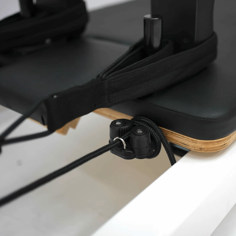 Close-up of the double-loop handle and part of the carriage on Core Collab Queen Cadillac Pilates Reformer