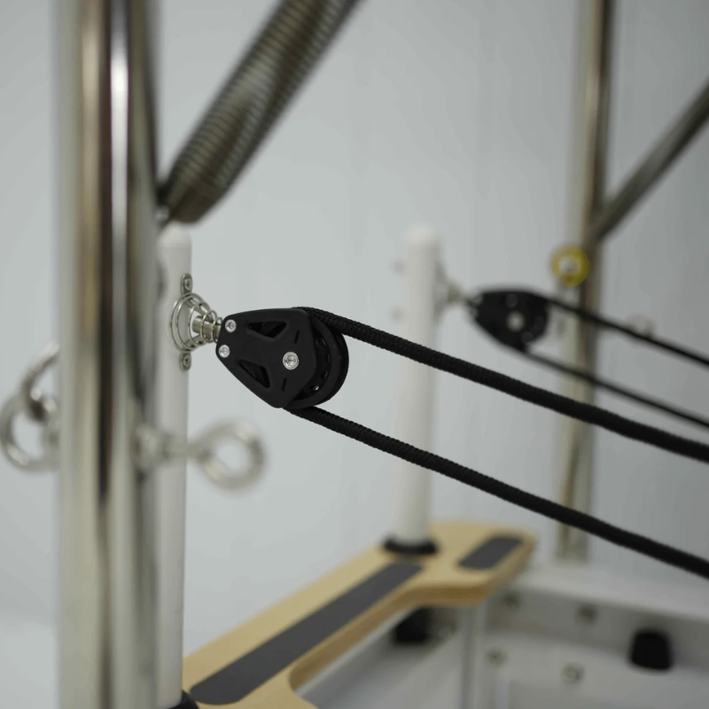 Close-up of the pulleys on Core Collab Queen Cadillac Reformer with full trapeze table