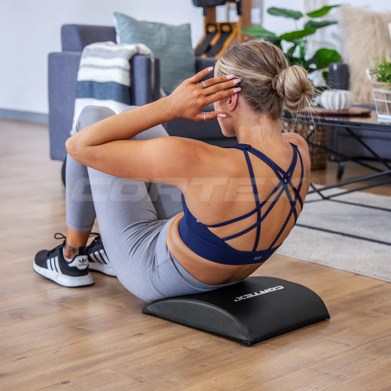 Woman in an upper position of a sit-up on on the Cortex Ab Exercise Mat in a living room