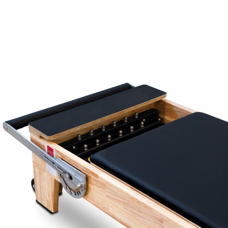 Close-up of the standing platform on the Impact Fitness Oak Wood Pilates Reformer Machine