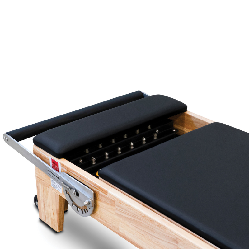 Close-up of the padded standing platform on the Impact Fitness Oak Wood Pilates Reformer Machine