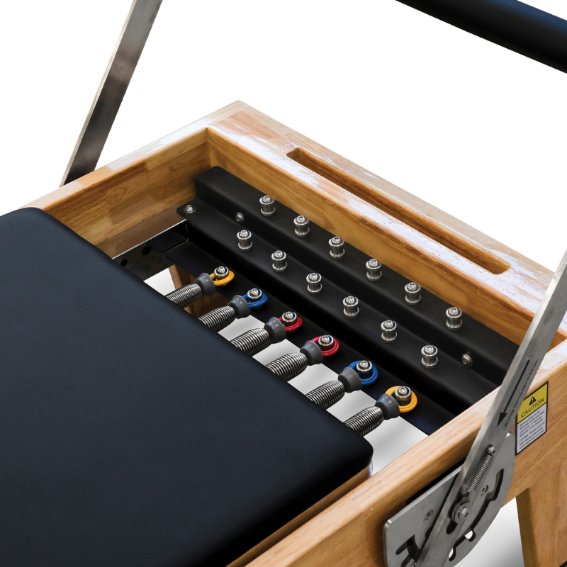 Close-up of the spring levels on the Impact Fitness Oak Wood Pilates Reformer Machine