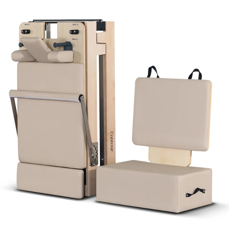 Folded state of the Contour folding wooden pilates reformer machine in Beige and its sitting box and jump board