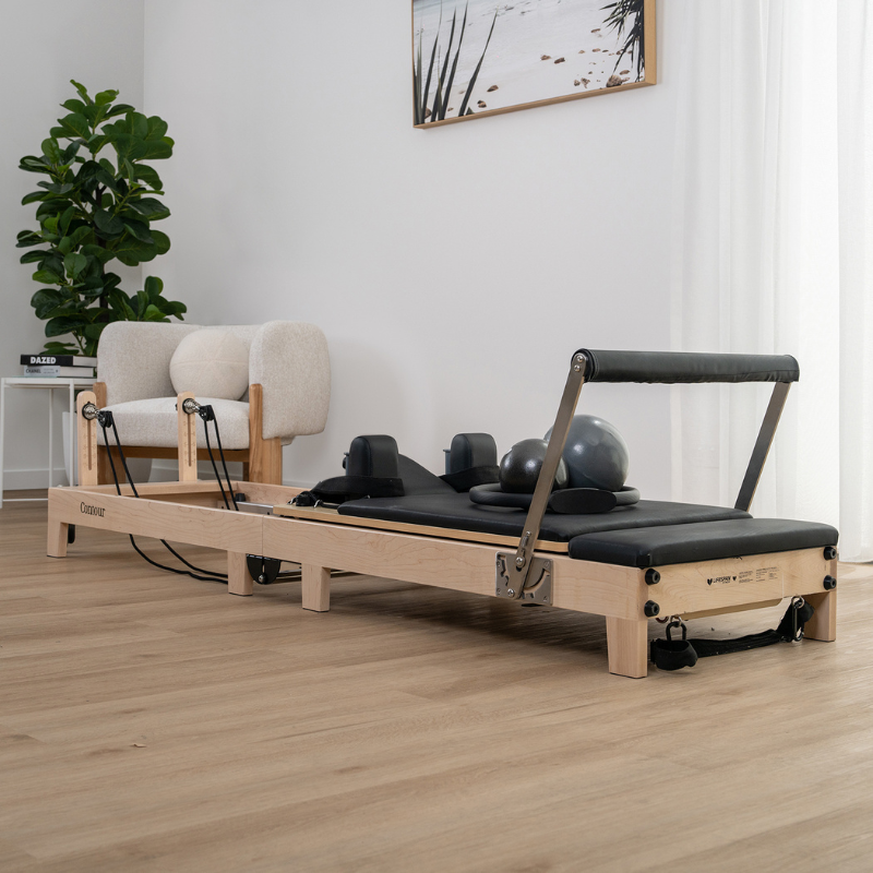 The Contour folding wooden pilates reformer machine sitting in a home lounge