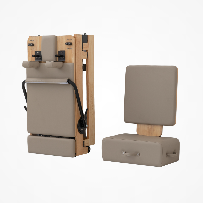 Front side angled view of Reformys Cloud Foldable Pilates Reformer in Beige with Pilates sitting box and jumpboard next to it