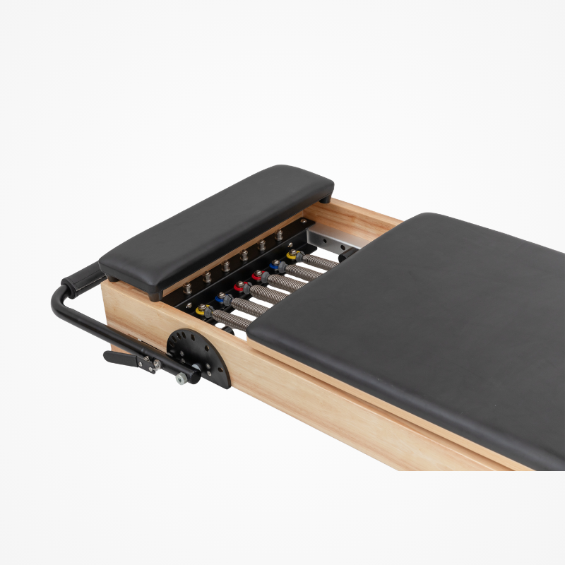 Closer view of the padded standing platform, springs, and carriage bed on the Reformys Cloud Portable Pilates Reformer in Black