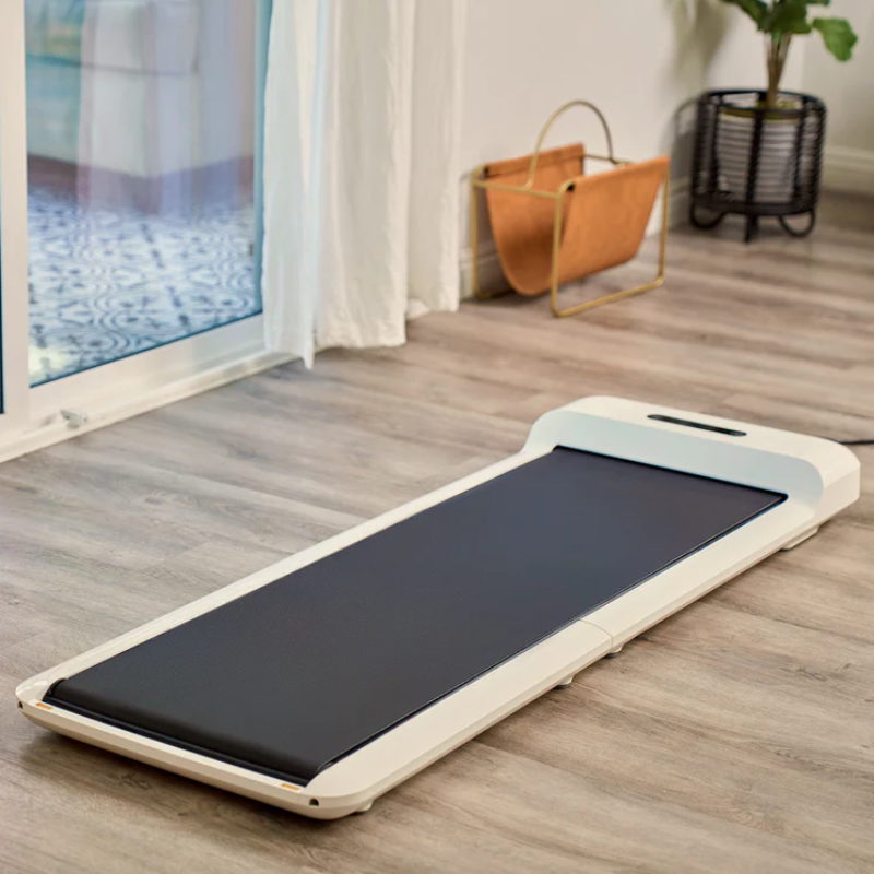 WalkingPad C2 Compact Folding Treadmill unfolded and laid on the ground inside a home lounge