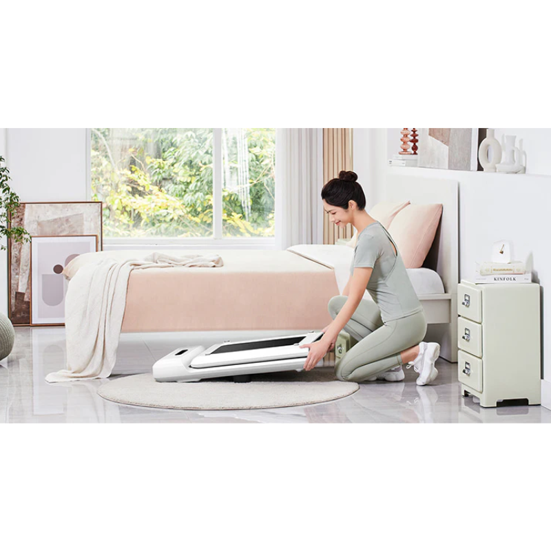 Woman storing away the WalkingPad C2 Compact Folding Treadmill in White in a bedroom
