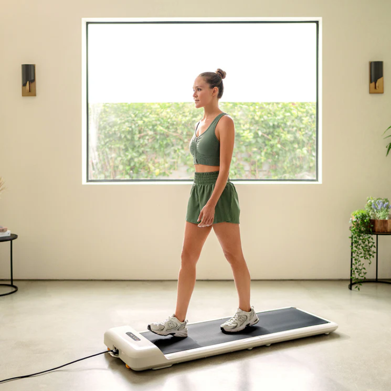Woman walking on the WalkingPad C2 Compact Folding Treadmill in a home gym