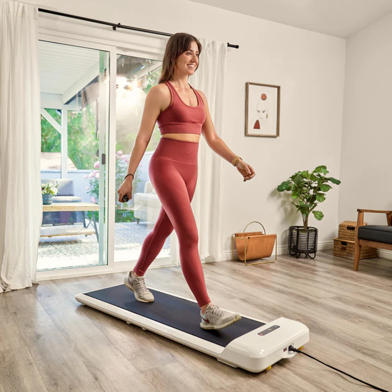Woman walking on the WalkingPad C2 Compact Folding Treadmill in White inside home lounge