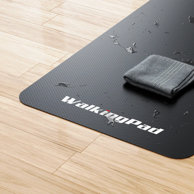 Close-up of WalkingPad Treadmill Mat covered in water splashes and a sweat towel laid on top of it