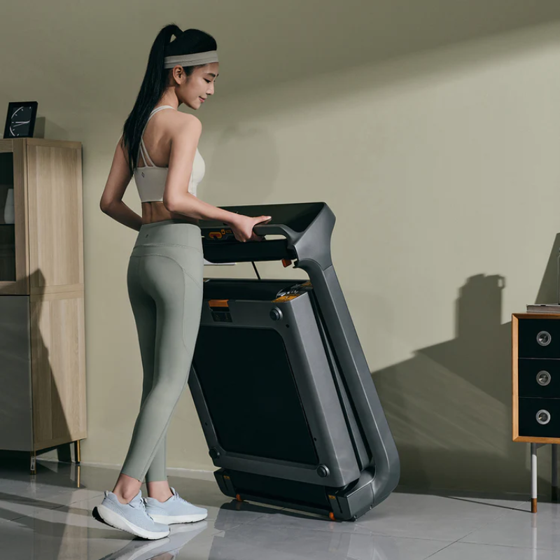 Woman stowing away the WalkingPad X218 Foldable Treadmill in her lounge