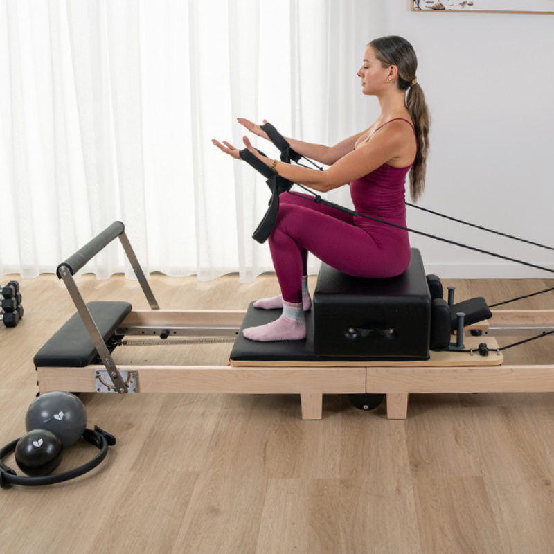 Woman exercising on the Lifespan Fitness Contour Folding Wooden Pilates Reformer Machine