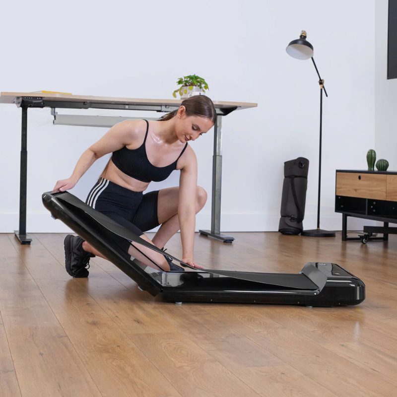 Woman folding up Lifespan Fitness M2 Walking Pad Treadmill