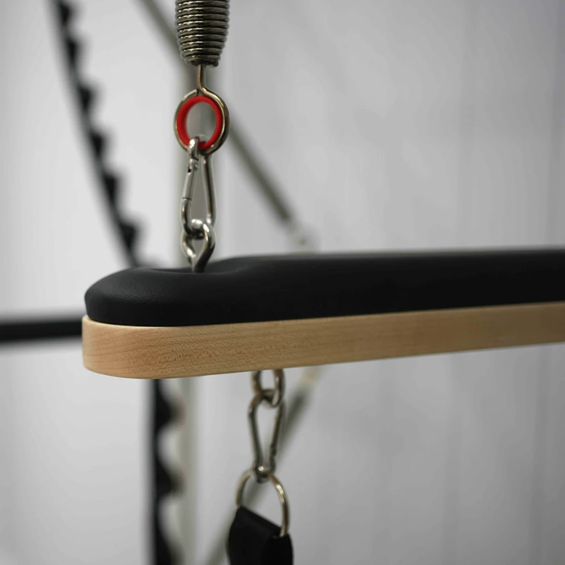 Close-up of the push-through bar on Core Collab Queen Pilates Cadillac Reformer with full trapeze table