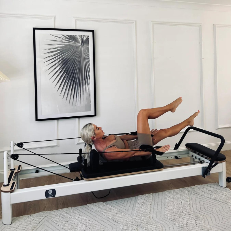 Woman Using Core Collab The Queen Pilates Reformer Angle View