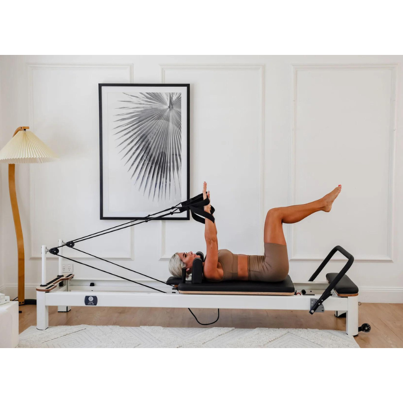 Woman Using Core Collab The Queen Pilates Reformer Side Angle