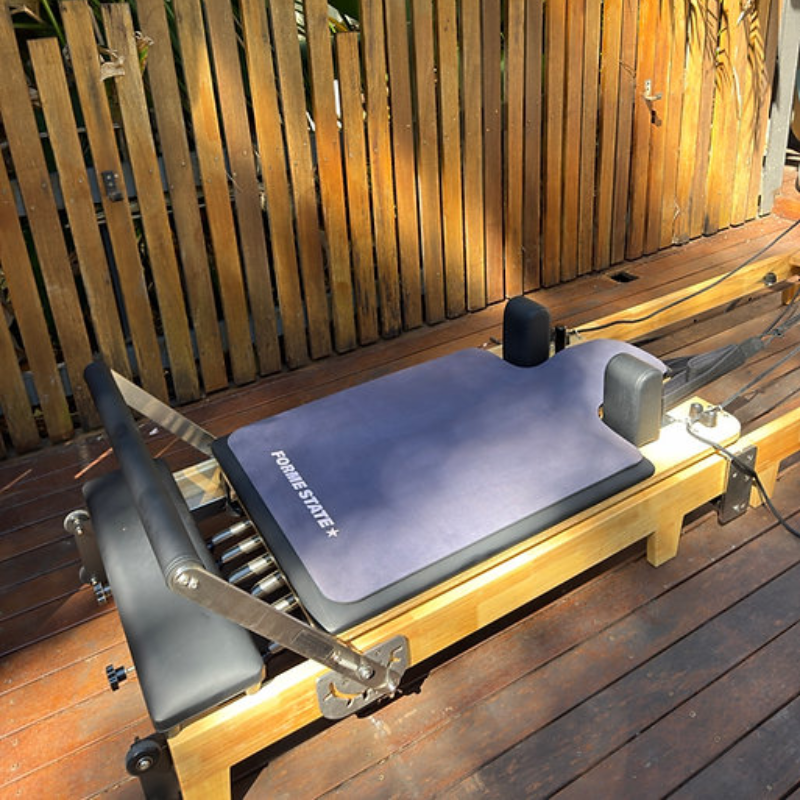 Forme State Pilates Reformer Mat in Charcoal in a home backyard