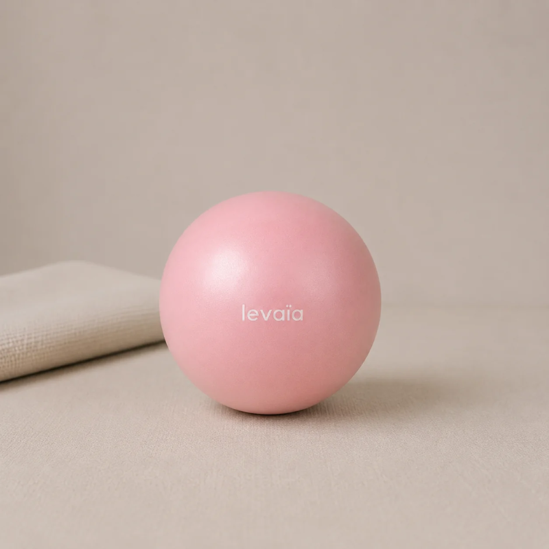 levaïa luna Soft Pilates Ball in Blush, resting on a beige surface beside a folded towel.