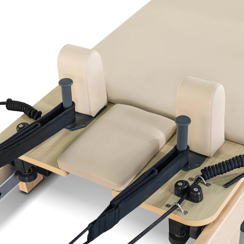 Close-up of the head rest, shoulder rests and straps on the Lifespan Fitness Contour Folding Wooden Pilates Reformer Machine in Beige