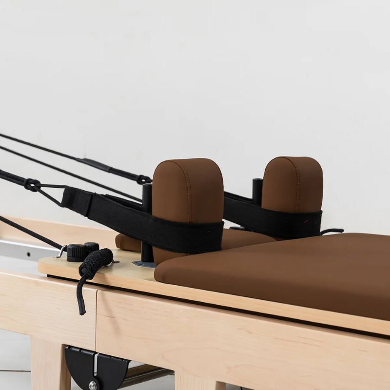 Close-up of the carriage and shoulder rests on the Lifespan Fitness Contour Folding Wooden Pilates Reformer Machine in Espresso