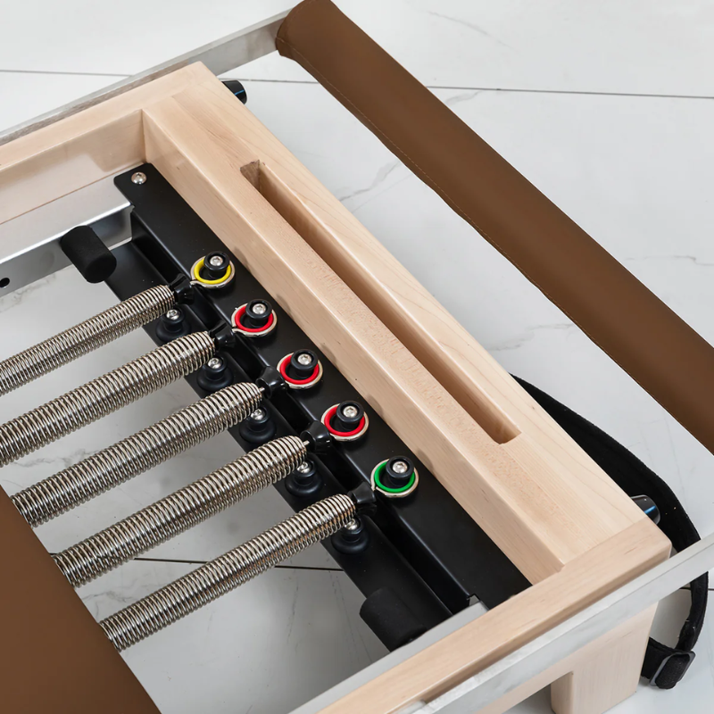 Close-up of the five springs attached on the Lifespan Fitness Contour Folding Wooden Pilates Reformer Machine in Espresso