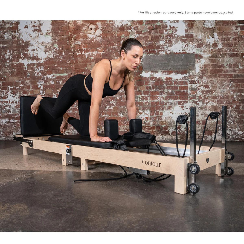 A woman exercising on her hands and knee on the Lifespan Fitness Contour Folding Wooden Pilates Reformer Machine in Black