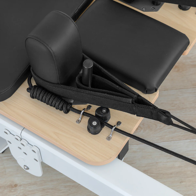 Close-up of the double-loop handle resting on one of the shoulder rests on the Lifespan Fitness Contour Pro Aluminium Folding Pilates Reformer in Black