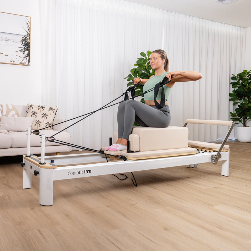 Woman exercising on the Lifespan Fitness Contour Pro Aluminium Pilates Reformer Machine in her lounge