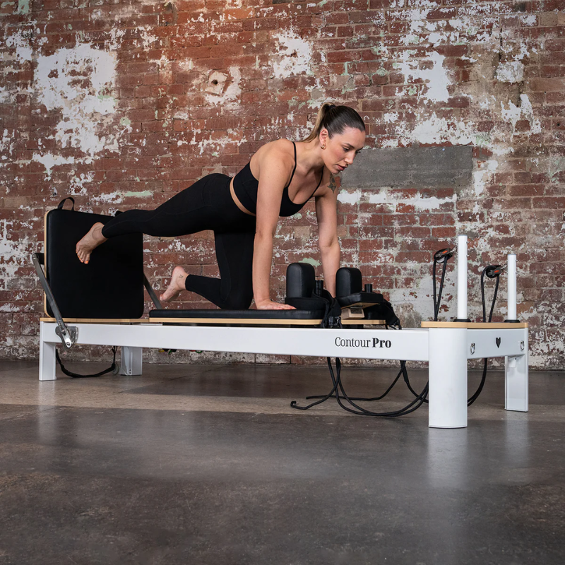 Woman doing Pilates workout on the Lifespan Fitness Contour Pro Aluminium Pilates Reformer Machine in Black