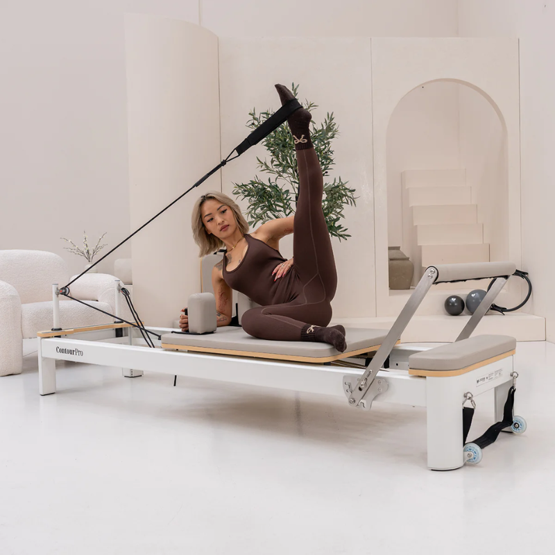 Woman exercising on the Lifespan Fitness Contour Pro Aluminium Pilates Reformer Machine in Hepburn inside a modern studio