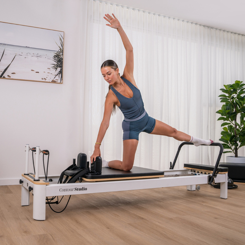 Woman working out on the Lifespan Fitness Contour Studio Commercial Pilates Reformer Machine