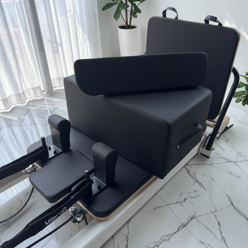 Close-up of the carriage, jumpboard, Pilates box, and standing platform facing the front on Milaron Pearl V3 Studio Pilates Reformer in Original