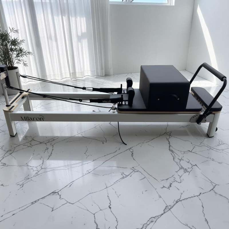 Side view of the Milaron Pearl V3 Pilates Reformer Machine in Original with Pilates box on top of carriage