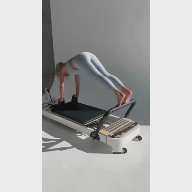 Woman exercising on the Core Collab Queen Studio 2.0 Reformer Machine for Pilates in Black