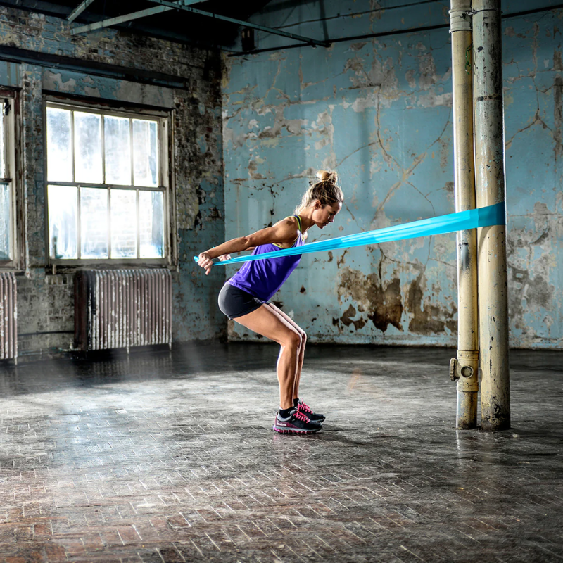 Woman working out by pulling on the Reebok Resistance Band