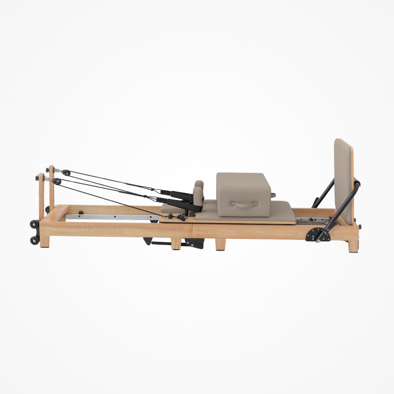 Right side view of the Reformys Cloud Portable Pilates Reformer in Beige with jumpboard