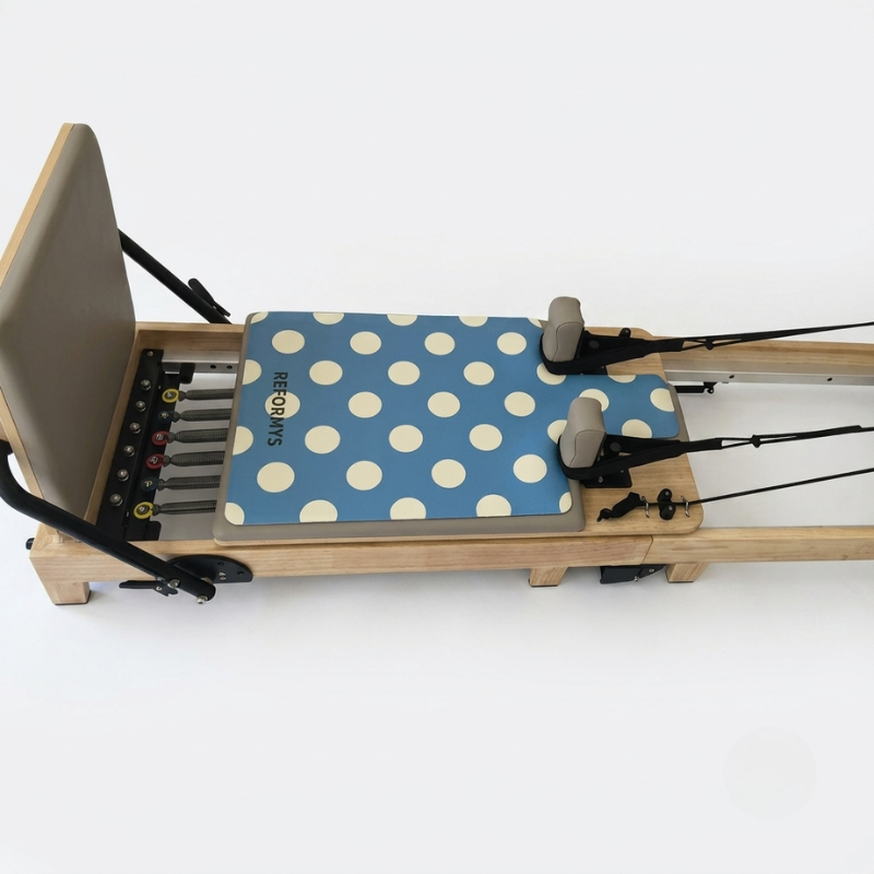Reformys Pilates Reformer Mat in Ocean Dot on a reformer Pilates machine with white background