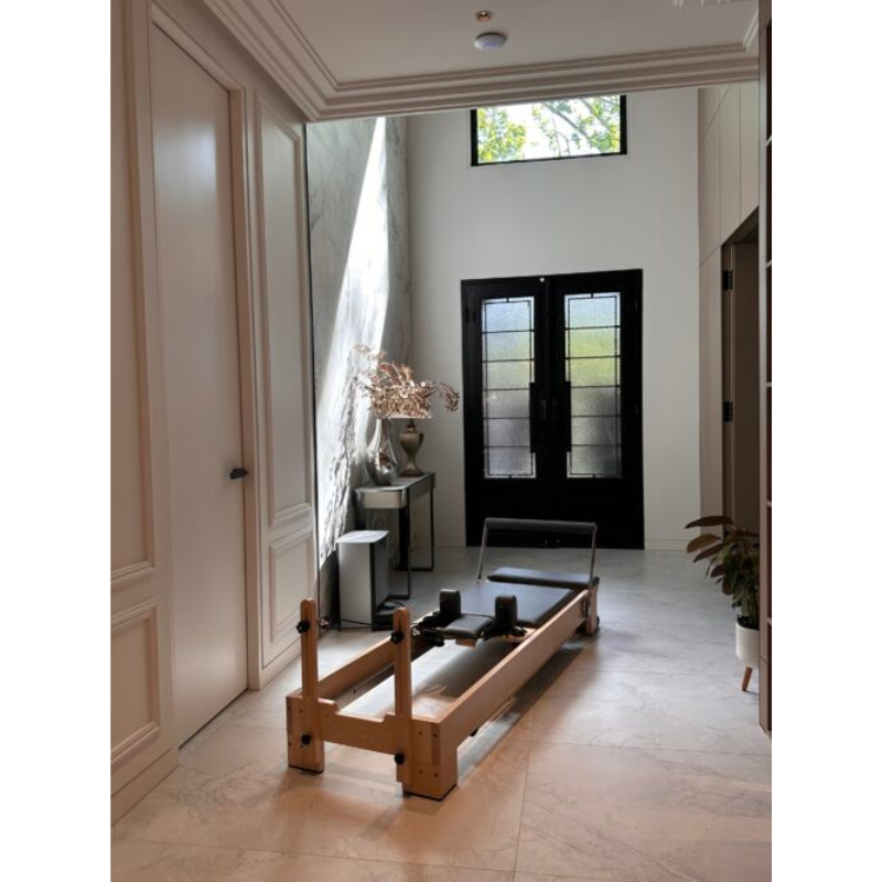 Volt Q2 Maple Wood Studio Pilates Reformer in a large entry way at home